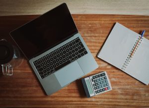 Laptop, calculator and notebook on a desk